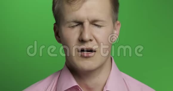 年轻沮丧的男人在绿色的关键背景下哭泣视频的预览图