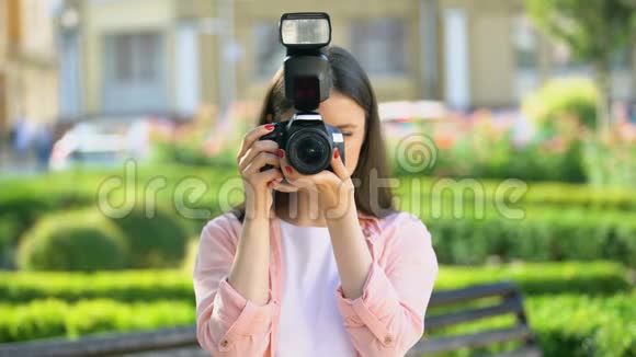 女摄影师在公园用相机拍照为初学者上课视频的预览图