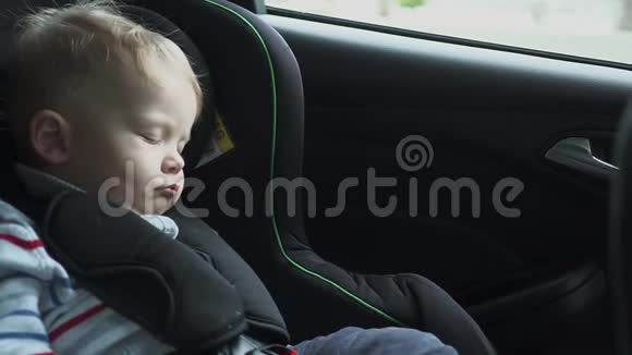 婴儿睡在碍事的车里坐在后座上的睡童慢动作高清高清视频的预览图