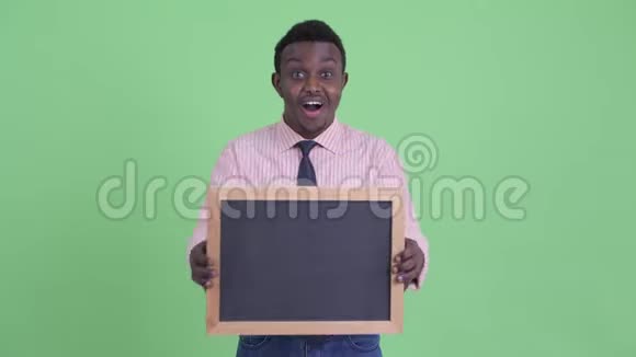 快乐的年轻非洲商人拿着黑板看上去很惊讶视频的预览图