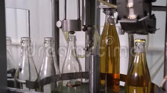 在工厂用玻璃瓶装柠檬水带玻璃瓶的传送带输送机特写的进程视频的预览图