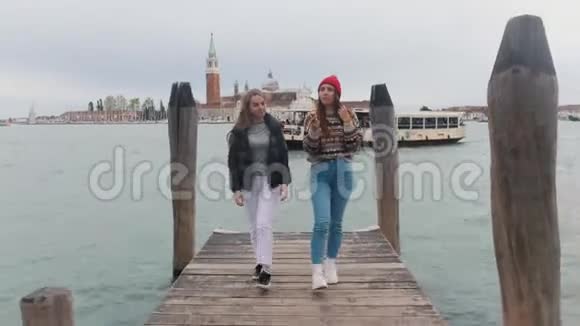 两个年轻女子沿着码头直接走到镜头前一边走一边走视频的预览图