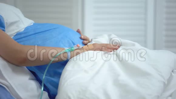 孕妇拿着毯子感觉腹痛有流产的危险视频的预览图