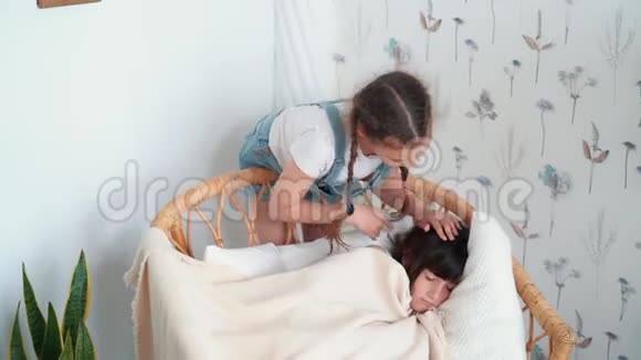 小可爱的女孩在椅子上睡着了姐姐盖上毯子动作很慢视频的预览图