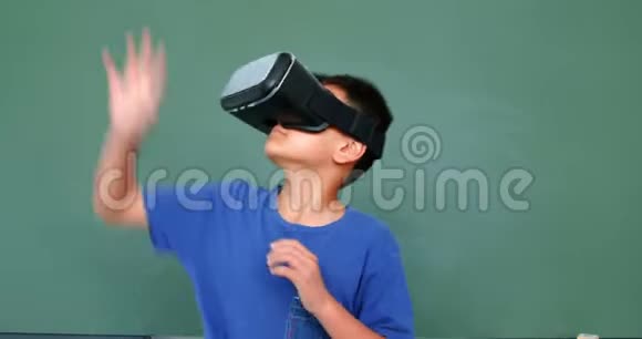 4k教室中使用虚拟现实耳机对绿色黑板的亚洲小学生正面观看视频的预览图