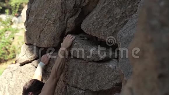 运动员攀岩者在悬崖上攀爬伸手抓住系上安全绳视频的预览图