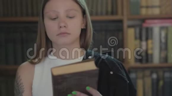 年轻可爱的女学生把书放在书架上的肖像一个图书馆的特写女孩把时间花在视频的预览图