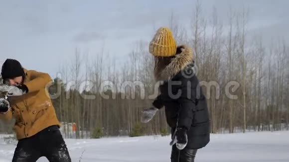 这对年轻夫妇正在冬林里打雪仗视频的预览图