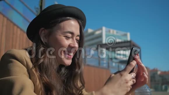快乐的黑发女人阅读短信和观看图片在智能手机特写视频的预览图