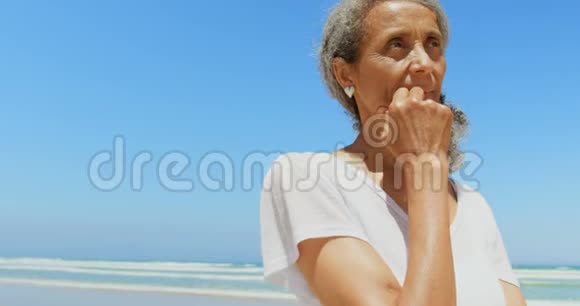 站在海滩4k的美国黑人高级妇女的正面景色视频的预览图