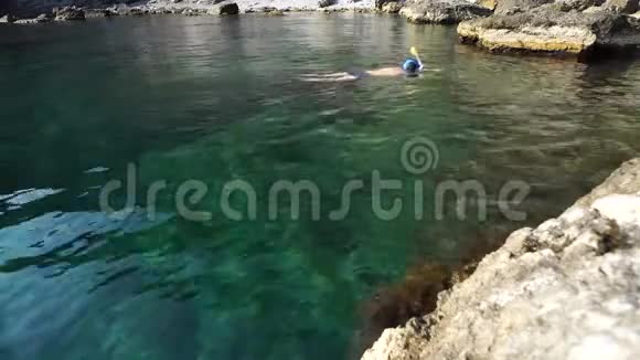 一个人戴着浮潜面具潜入晶莹剔透的大海用动作相机移除水下世界视频的预览图