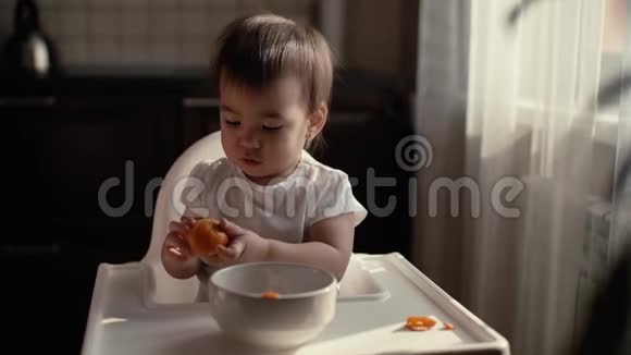 小女孩穿着漂亮的绿色围兜慢慢地打扫卫生吃橘子视频的预览图