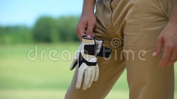 男性高尔夫球手戴着定性的白色手套准备玩精英爱好视频的预览图