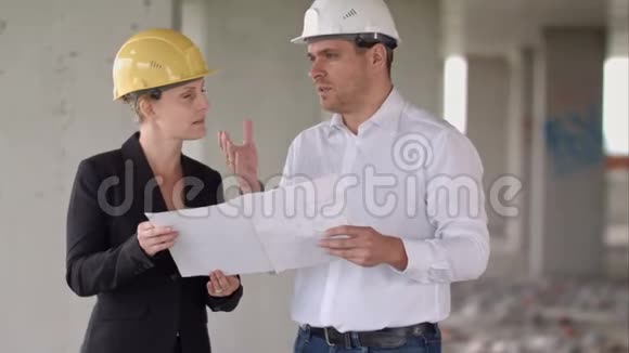 两名戴防护头盔的建筑师在建筑工地施工视频的预览图