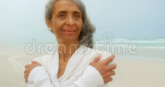 在海滩上瑟瑟发抖的富有思想的活跃的非裔美国妇女的正面景色视频的预览图