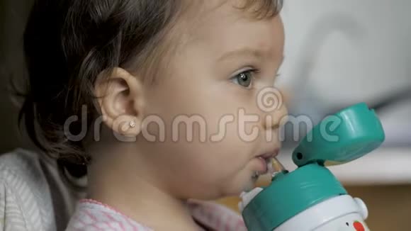 可爱的女婴用吸管从瓶子里喝水视频的预览图