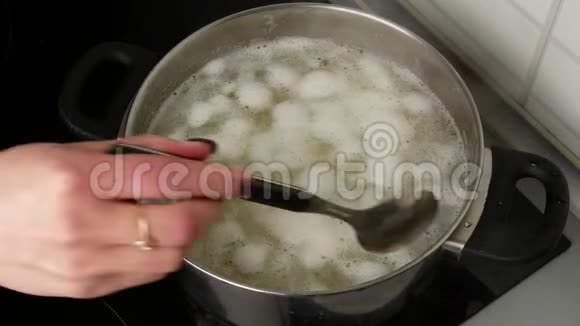 快关门女人手用煮土豆从锅里取出泡沫视频的预览图