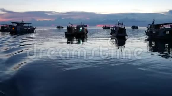日落时船在港口漂浮高涛港海面上的钓鱼和潜水艇视频的预览图