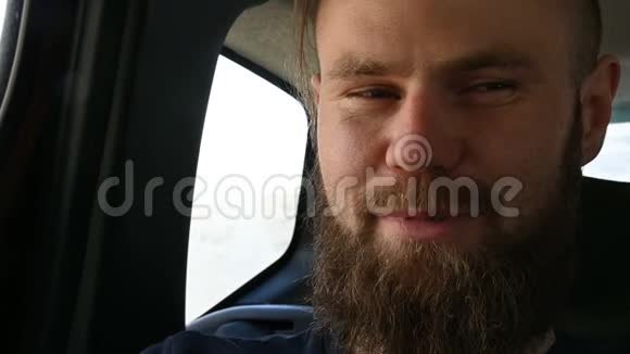 一个满脸笑容的留胡子的男婴坐在后座的车里边看边沉思视频的预览图