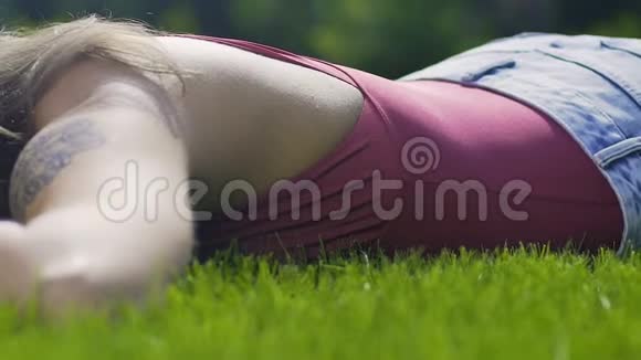 伤心的心碎的女人躺在草地上凝视结束关系悲伤视频的预览图