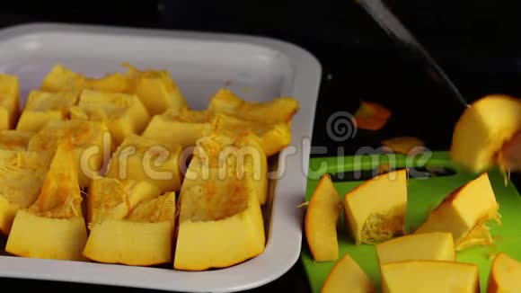 一个人把一个橙色的南瓜切成碎片碎片堆在托盘上世界素食日视频的预览图