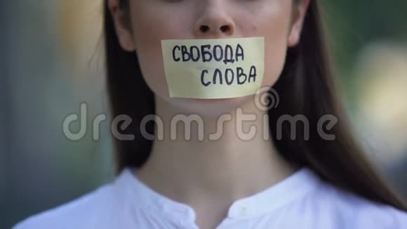 带着言论自由的女人用俄语从嘴上取下磁带视频的预览图