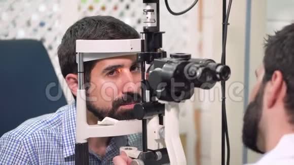 眼科医生在眼科诊所检查年轻人视力病人视频的预览图