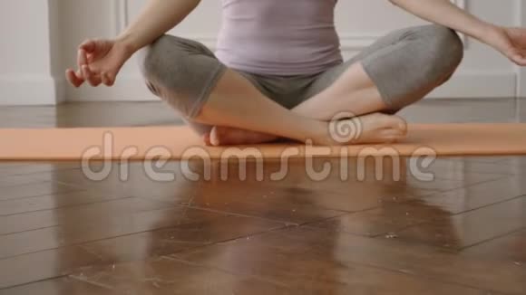 一个年轻漂亮女人的肖像坐在莲花的垫子上练习瑜伽视频的预览图