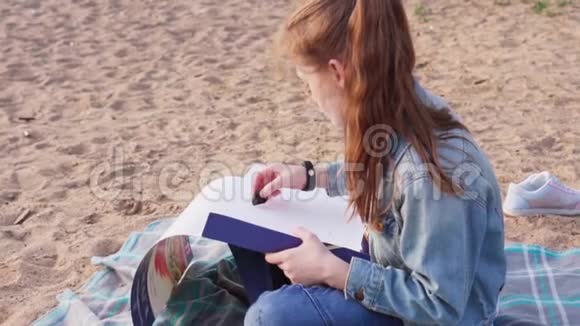 女孩在夏天的海滩上画煤视频的预览图