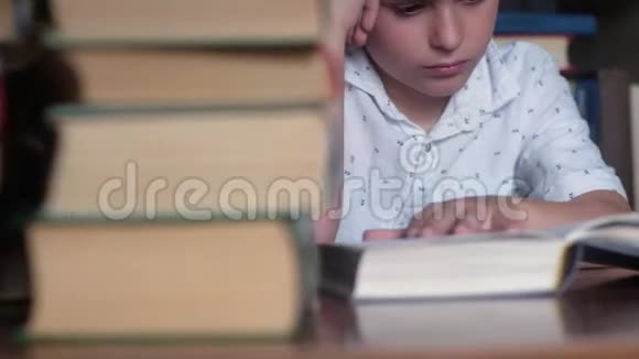 坐在桌子旁的男孩的特写读书小姐翻页视频的预览图