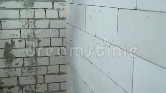 建筑工人用电钻将螺丝拧入砌块墙视频的预览图