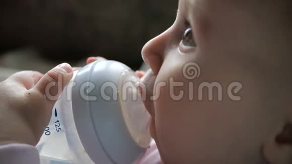 可爱的宝宝坐着用吸管从瓶子里喝水视频的预览图