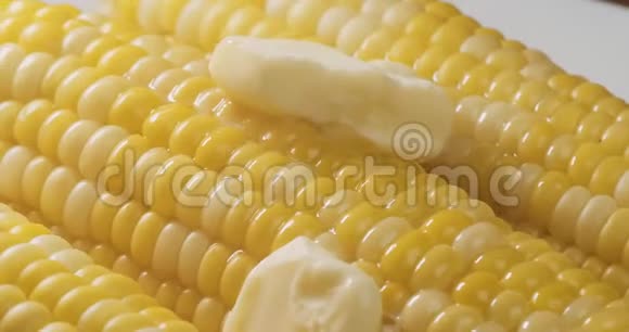 新鲜煮熟的玉米配上融化的黄油的美丽镜头视频的预览图