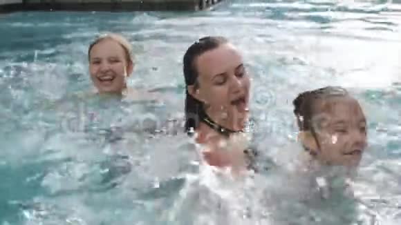 母亲带着两个女儿游泳在开阔的天空下的游泳池里玩得很开心视频的预览图