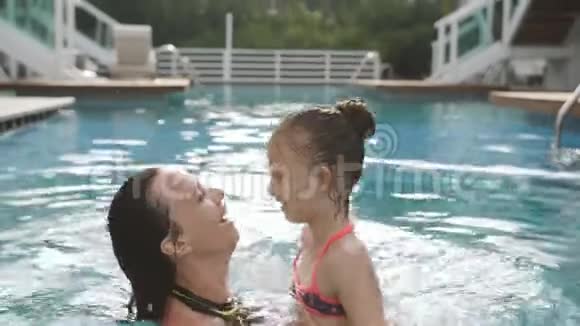 快乐的母女玩得开心在游泳池里游泳视频的预览图