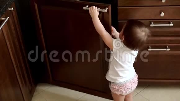 小可爱的女孩独立地缓慢地打开厨房的门视频的预览图
