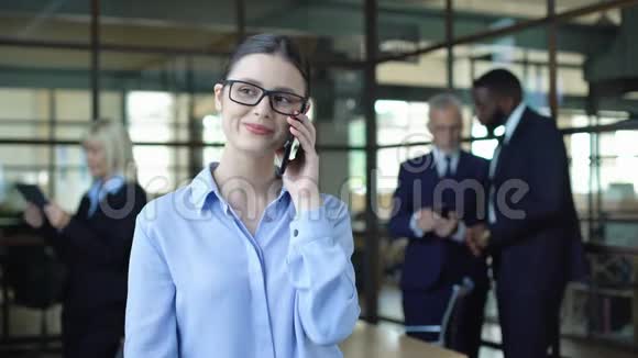 微笑商务女性在工作休息时打电话移动交谈视频的预览图