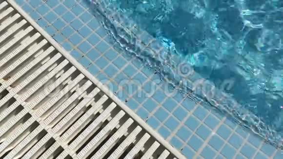 在蓝色瓷砖游泳池和白色排水烤架中的水波浪清视频的预览图