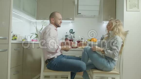 在厨房里品尝红酒的幸福夫妻视频的预览图