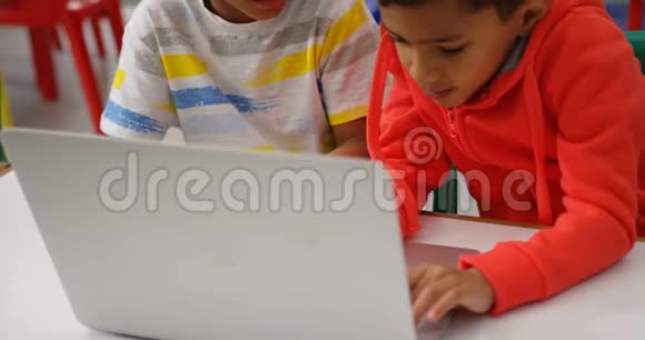 在4k教室里用笔记本电脑学习的混血学童的正面景色视频的预览图