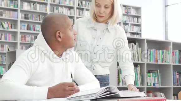 可爱的大学情侣在图书馆学习时聊天视频的预览图