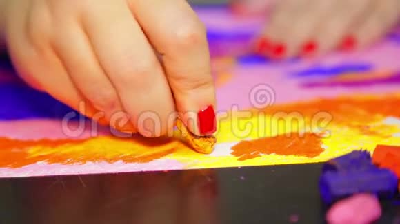 女人的手在白纸上画着夕阳下的黄色彩霞视频的预览图
