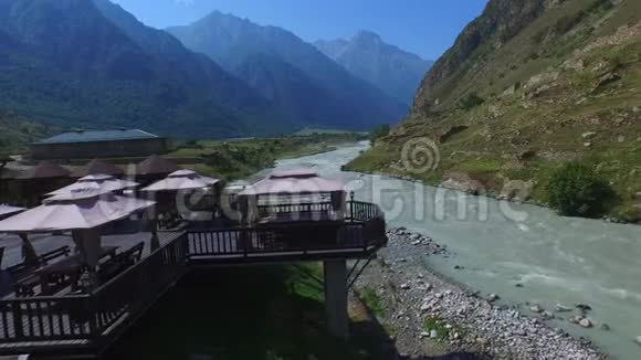 在桥上飞行可以看到高山河可以俯瞰高加索山脉4K视频的预览图