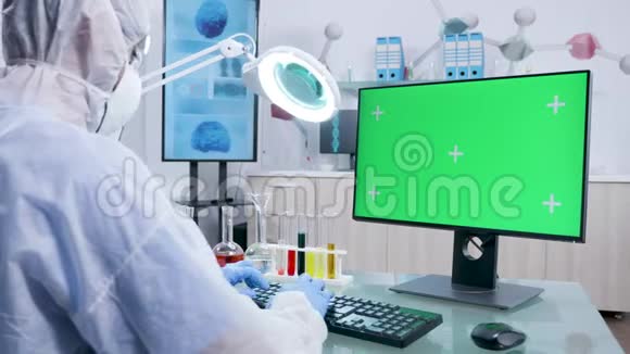 多利在绿色屏幕电脑上用白色封面打字的科学家视频的预览图