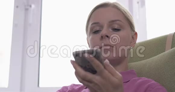 金发女子使用智能手机语音识别功能在线视频的预览图
