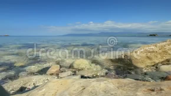 清澈的海水正在冲刷海岸上的砾石背景为地平线的特写镜头视频的预览图
