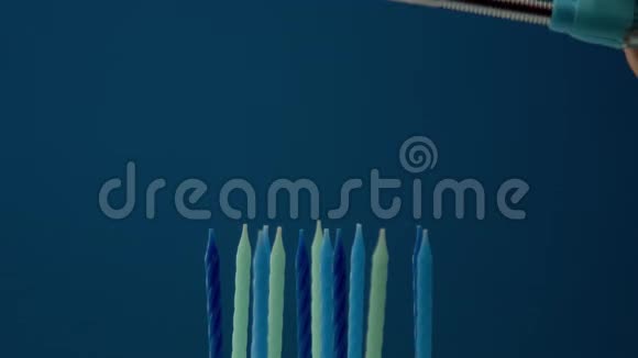 一些冷色调的蜡烛放在蓝色背景上有人点蜡烛视频的预览图