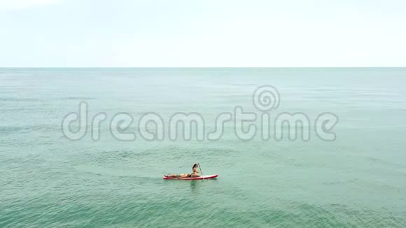 空中观景一对年轻夫妇漂浮在无边的绿松石海上视频的预览图