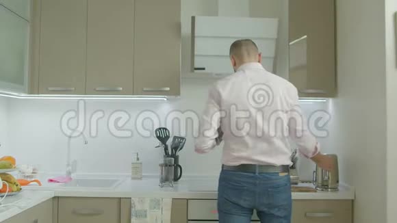 帅气的单身男人在厨房泡茶视频的预览图
