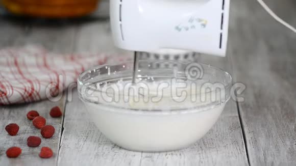 女人在鲜奶油里加入糖粉做奶油做蛋糕视频的预览图
